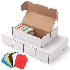 an open box with several books in it and four different colored folders next to it