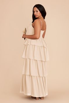 a woman in a white dress holding a flower