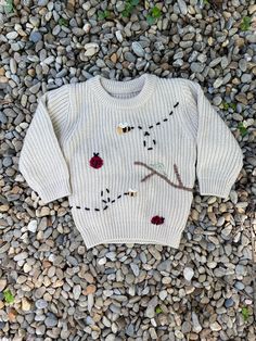 a white sweater sitting on top of a pile of rocks