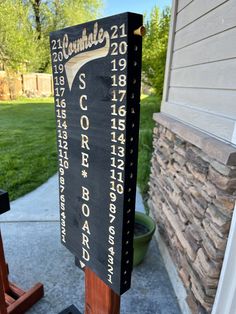 a wooden sign that is on the side of a building in front of a house