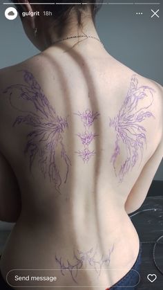 the back of a woman's body with tattoos on her upper and lower back