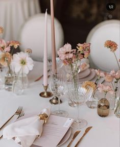 the table is set with flowers, candles and place settings for an elegant wedding reception