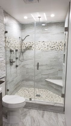 a walk in shower sitting next to a white toilet and bathtub with glass doors