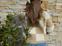 a woman standing in front of a brick wall with her back turned to the camera