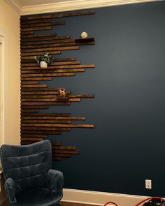 a living room with blue walls and wooden slats on the wall behind a chair