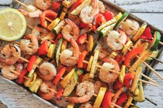 shrimp and vegetable kabobs on skewers with a lemon wedged in the middle