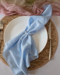 a plate with a blue napkin on top of it next to a fork and knife