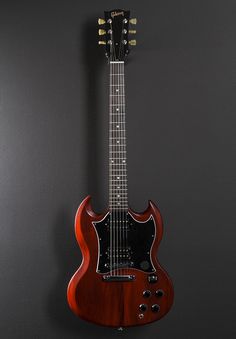 an electric guitar hanging on the wall