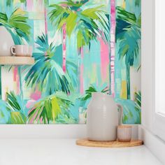 the wallpaper in this kitchen is painted with tropical palm trees and pink, blue, green