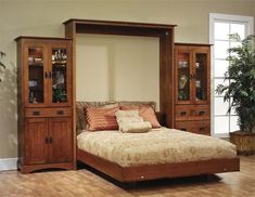 a large bed sitting inside of a bedroom next to a wooden dresser and mirror on top of a hard wood floor