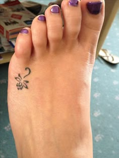 a woman's foot with a flower tattoo on it