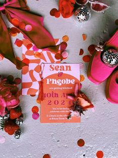 a pair of pink shoes sitting on top of a table next to confetti