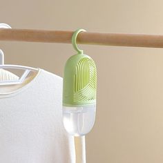 an air freshener hanging on a clothes line next to a white t - shirt