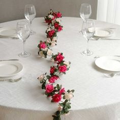 the table is set with white and pink flowers