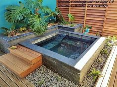 an outdoor hot tub surrounded by plants and rocks