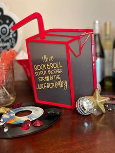 a blackboard sign sitting on top of a wooden table next to a cd case