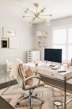 a white desk with a computer on top of it in a room next to a window