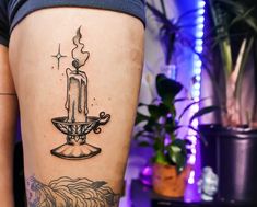 a woman's thigh with a candle tattoo on her left leg and an angel above the candle