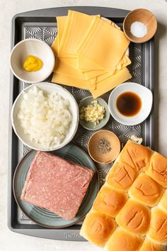 an assortment of food on a tray with chopsticks, sauce and other items