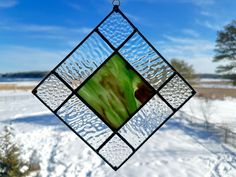 a stained glass window hanging in the snow