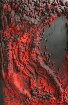 an abstract painting with red and black paint on the bottom half of it, in front of a dark background