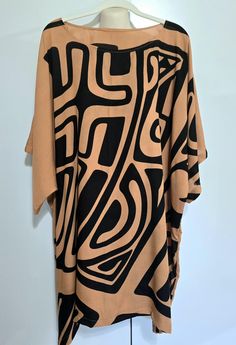 Hawaiian Aloha wear Tunic top or short dress.  Black on tan, HILO TRIBAL print.    Perfect island wear--Cool and comfortable island, dress up or dress down, for an evening out, office attire, or a day at the beach.  Hamd made in Hawaii.  Light weight 100% rayon.  One size fits most,  suggest Medium to 2xl Mannequin in the photo is a size x-small. Hand wash and hang to dry Brown V-neck Tunic For Summer, Printed Brown Tops For Vacation, Brown Printed Tops For Vacation, Beach Printed Brown Blouse, Beach Blouse With Brown Print, Brown Short Sleeve Beach Blouse, Summer Beach Blouse With Graphic Print, Brown Tops For Beach Vacation, Brown Tops For Vacation And Beach Season