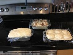 three uncooked rolls sitting on top of an oven next to each other in pans