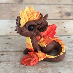 a small toy dragon sitting on top of a wooden table