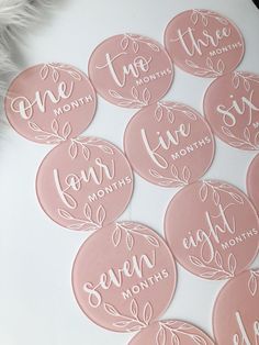 six pink stickers with the words one month and seven months written on them in cursive font