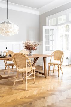 a dining room table with chairs and a chandelier hanging from it's ceiling