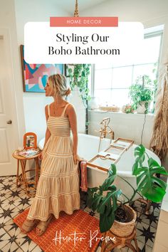 a woman standing in front of a bathtub with the words styling our boho bathroom