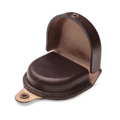 a brown leather case with a hole in the middle for a small object to hold