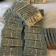 stacks of money sitting on top of a bed