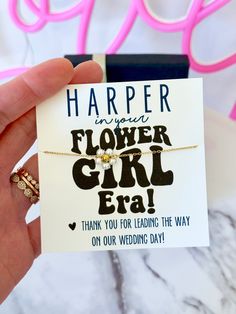 a hand holding a card that says, harper flower girl era thank you for leading the way on our wedding day