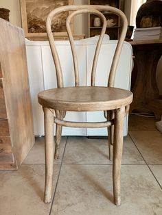 a wooden chair sitting on top of a tile floor