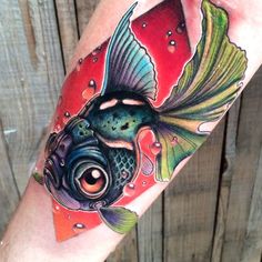 a colorful tattoo on the arm of a person with a fish in it's mouth