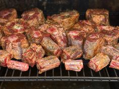 raw meat is cooking on an outdoor grill