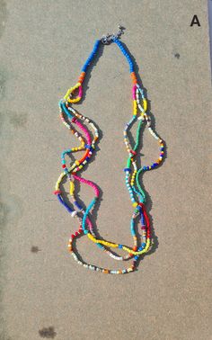 "Colorful vibrant multi beads multi-row summer necklace. This multi-layered multicolored necklace is made of mixed beads and seed beads and sequin beads. This Mexican multi-colored necklace is an ideal necklace for the Summer. The necklace is approx. 26\" long and has three rows. The drop length is approx. 13-14\". Available in two options: A - Blue beads B - White beads * The products are handmade and shipped from India. * Package preparation time is 1 - 2 business days. * Standard shipping - T Cheap Bohemian Rainbow Necklaces, Cheap Multicolor Long Necklace With Colorful Beads, Long Colourful Beaded Necklaces, Cheap Rainbow Necklaces With Colorful Beads, Luxury Multicolor Single Strand Beaded Necklaces, Cheap Rainbow Beaded Necklaces With Large Beads, Luxury Multicolor Necklace For Festivals, Multicolor Double Strand Beaded Chain Necklace, Multicolor Necklace With 108 Beads For Festivals