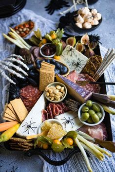 a platter filled with meats, cheeses, crackers and other foods