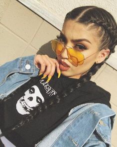 a woman with braids wearing sunglasses and a panda t - shirt is posing for the camera