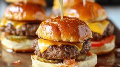 cheeseburger sliders with pickles and tomatoes on a wooden tray, ready to be eaten