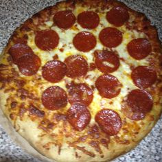 a pepperoni pizza sitting on top of a counter