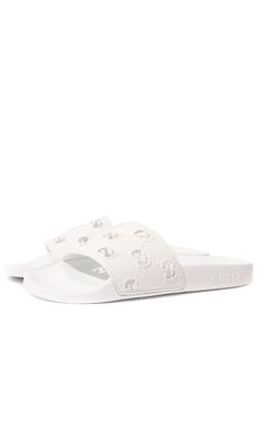 On these white rubber slippers, the diamond-shaped pattern in the form of GG monograms, plays not only a decorative, but also a functional role. An openwork motif, made in the technique of perforations, conducts heat well from the legs. This comfort is also supported by an orthopedic insole that reduces the load on the joints.Composition: Rubber 100%Lining: Rubber 100%Sole: Rubber 100%Made in Italy Designer White Sandals With Rubber Sole, Classic White Slides With Round Toe, Elegant White Flat Slides, White Gucci Sandals With Branded Insole, White Gucci Open Toe Sandals, Luxury Gucci Slides With Rubber Sole, Luxury White Slip-on Sandals, Designer White Sandals With Cushioned Footbed, White Textured Sole Slip-on Slides