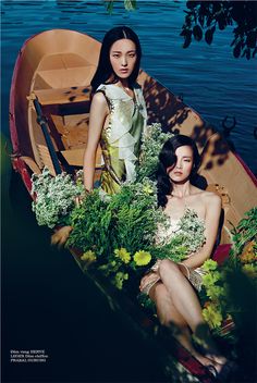 two women sitting in a boat with flowers