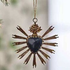 an ornament hanging from a tree branch with a blue heart in the center