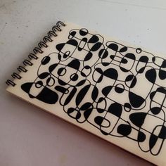 a piece of paper with black and white designs on it, sitting on a table