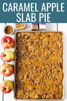 caramel apple slab pie with apples around it on a white wooden table and text overlay that reads, caramel apple slab pie