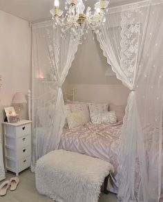 a bedroom with a white canopy bed and pink comforter