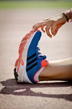 a woman's foot is touching her running shoe