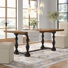 a dining room table with chairs around it and a rug on the floor next to it